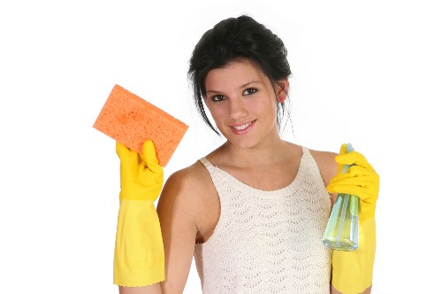 Cleaner working on shopfront window cleaning in SE10